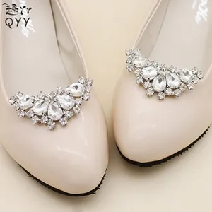Close-up of sparkling rhinestone buckles on elegant beige bridal shoes with crystal accents