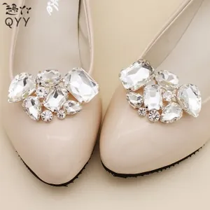Detailed close-up of sparkling rhinestone shoe buckles on elegant apricot pointed-toe flats