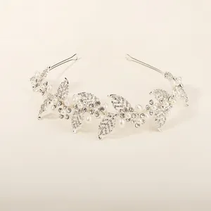 Close-up of bridal headband with silver alloy leaves, white pearls and sparkling rhinestones