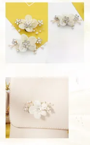 Detail of white fabric flower shoe clip with pearls and rhinestones on a beige bag