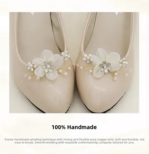 Detail of handmade bridal shoe clips featuring faux pearls and copper wire flowers