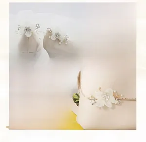 Detailed macro view of handmade fabric flower shoe clip with pearls and golden wire