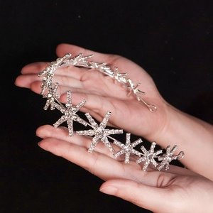 Elegant silver star headband with micro-p鑲ed rhinestones held in hand on black background