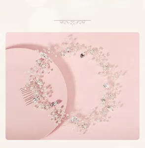 Detail of silver bridal hair comb with pearls, rhinestones and leaf motifs for weddings