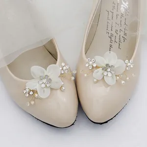 Elegant bridal shoe clips with white fabric flowers, pearls, and rhinestones