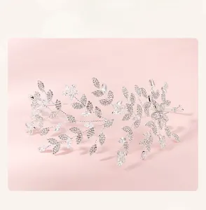 Detailed close-up of a silver bridal headband featuring crystal leaves and floral motifs