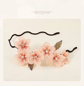 Macro view of floral embroidery headband with pink petals and colorful beaded leaf details