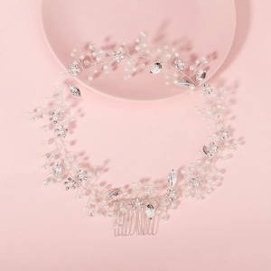 Elegant bridal hair comb with pearls, crystals and silver leaves on pink background