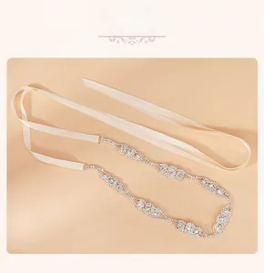 Détail d'une ceinture de mariée élégante avec fleurs en strass et rubans en satin