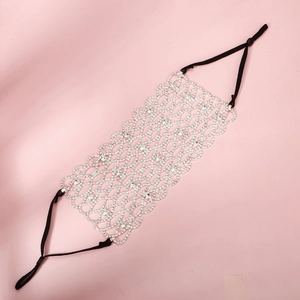 Detailed macro view of silver mesh mask with sparkling rhinestones for party wear