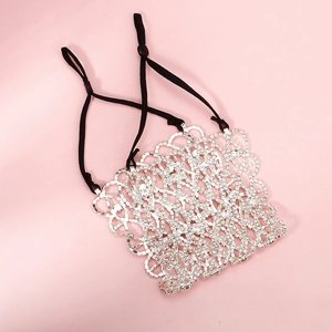 Detail of silver rhinestone mesh accessory with adjustable black elastic straps on pink surface