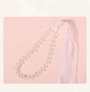 Détail d'un serre-tête de mariée en perles avec rubans en mousseline rose tendre