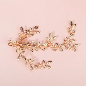 Elegant gold leaf hair clip with white pearls and sparkling crystals on pink background