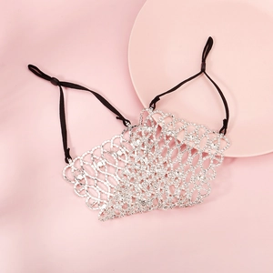 Detail of silver rhinestone mesh mask with adjustable black ear loops on pink surface