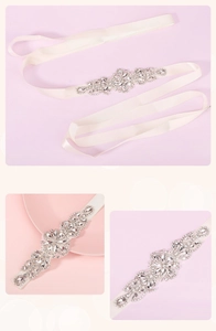 Detail of luxury bridal sash featuring sparkling rhinestones on a smooth cream ribbon