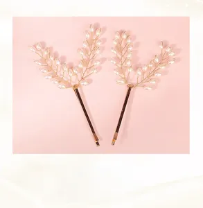 Close-up of handmade gold wire hair clips with white pearls in a minimalist design