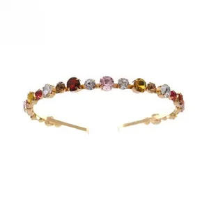 Detailed view of luxury gold headband with multi-colored zircon crystals and prong setting