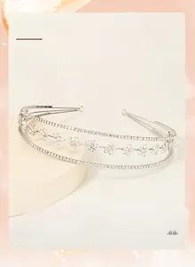 Detailed close-up of bridal rhinestone tiara featuring silver flower metal designs