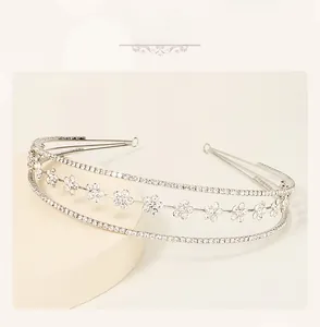 Detailed view of silver flower headband with three layers of shimmering rhinestones