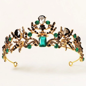 Detail of baroque crown with emerald and black crystals on gold-tone alloy frame