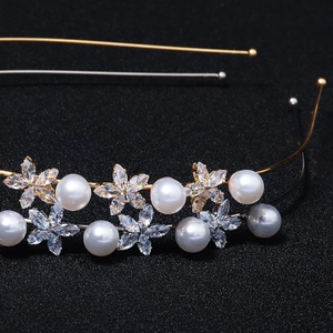 Détail macro de fleurs en perles et zircons sur des serre-têtes en or et en argent