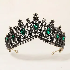 Detail of luxury Baroque bridal tiara featuring emerald green gems and black rhinestones