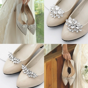 Close-up of sparkling rhinestone shoe buckles on elegant beige pointed-toe bridal pumps