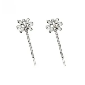 Détail de barrettes argentées avec fleurs en cristal et longues franges en strass