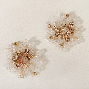 Close-up of handmade bridal shoe clips featuring gold wire pearls and crystal rhinestones