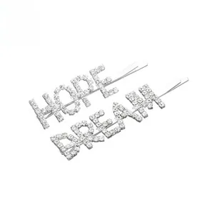 Détail des barrettes HOPE et DREAM argentées ornées de strass brillants scintillants