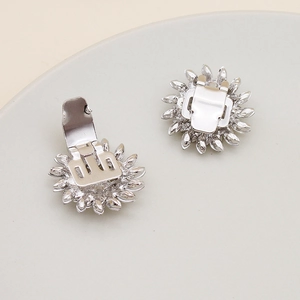 Detailed view of rhinestone floral shoe clips with silver alloy base and metal fasteners