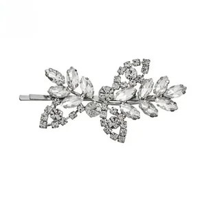 Détail d'une pince à cheveux argentée en forme de feuille avec strass brillants