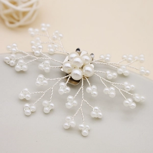 Macro shot of silver pearl bridal hair clip with intricate wire floral design