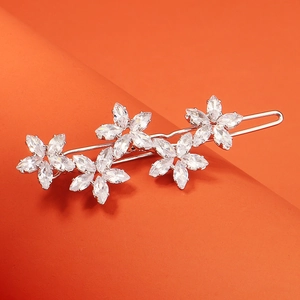 Barrette fleurie élégante en argent avec zircons sur un fond orange vif