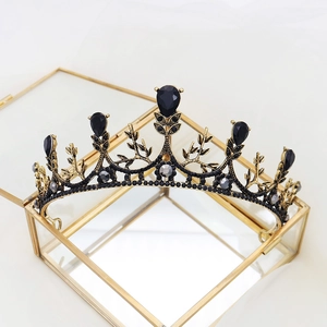 Detail van vintage zwarte strass bruidskroon op een gouden sieradendoosje