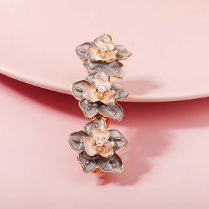 Détail de la pince à cheveux fleurs en émail vintage avec perles sur fond rose