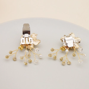 Detailed back view of gold bridal shoe clips featuring delicate leaf texture and pearls