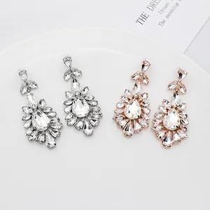 Close-up of bridal crystal drop earrings in silver and rose gold finishes for weddings