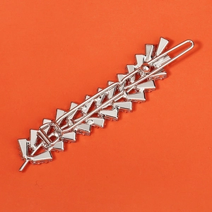 Elegant silver rhinestone hair clip with geometric wheat design on orange background