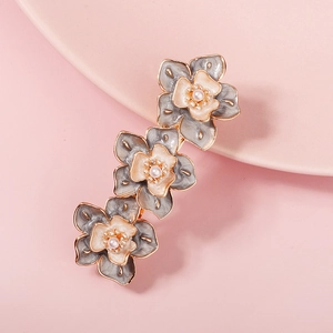 Détail de la pince à cheveux à trois fleurs avec pétales en émail gris et perles