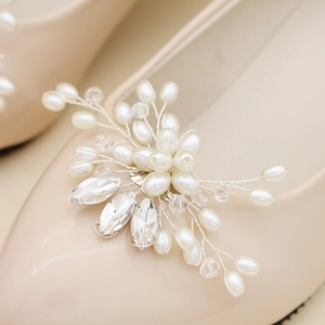 Macro view of luxurious pearl and rhinestone bridal shoe clip on a beige pointed heel