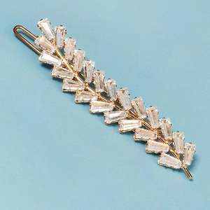 Vue détaillée d'une pince à cheveux épis de blé dorée avec des pierres de zircone brillantes