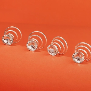 Vue détaillée de 4 épingles à cheveux spirales argentées avec strass brillants sur orange
