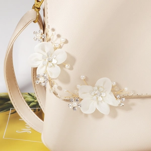 Detailed macro view of bridal shoe clip with white silk flowers and luxury pearls