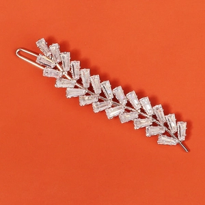 Close-up of elegant silver hair clip with rectangle-cut zircons in feather shape