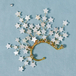 Detailed close-up of handmade bridal ear cuff with pearls and star-shaped crystal accents