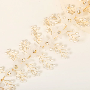 Makrodetail eines handgefertigten Braut-Haarkamms mit Harzblüten und Perlen für die Hochzeit