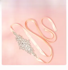 Detailed view of luxury bridal belt with sparkling crystal floral pattern on pink satin ribbon