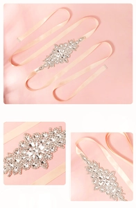Detail of luxury peach satin bridal belt with intricate rhinestone floral crystal patterns