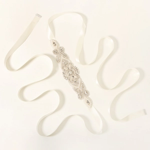 Detail of hand-sewn crystal bridal belt with pearls and rhinestones on satin ribbon